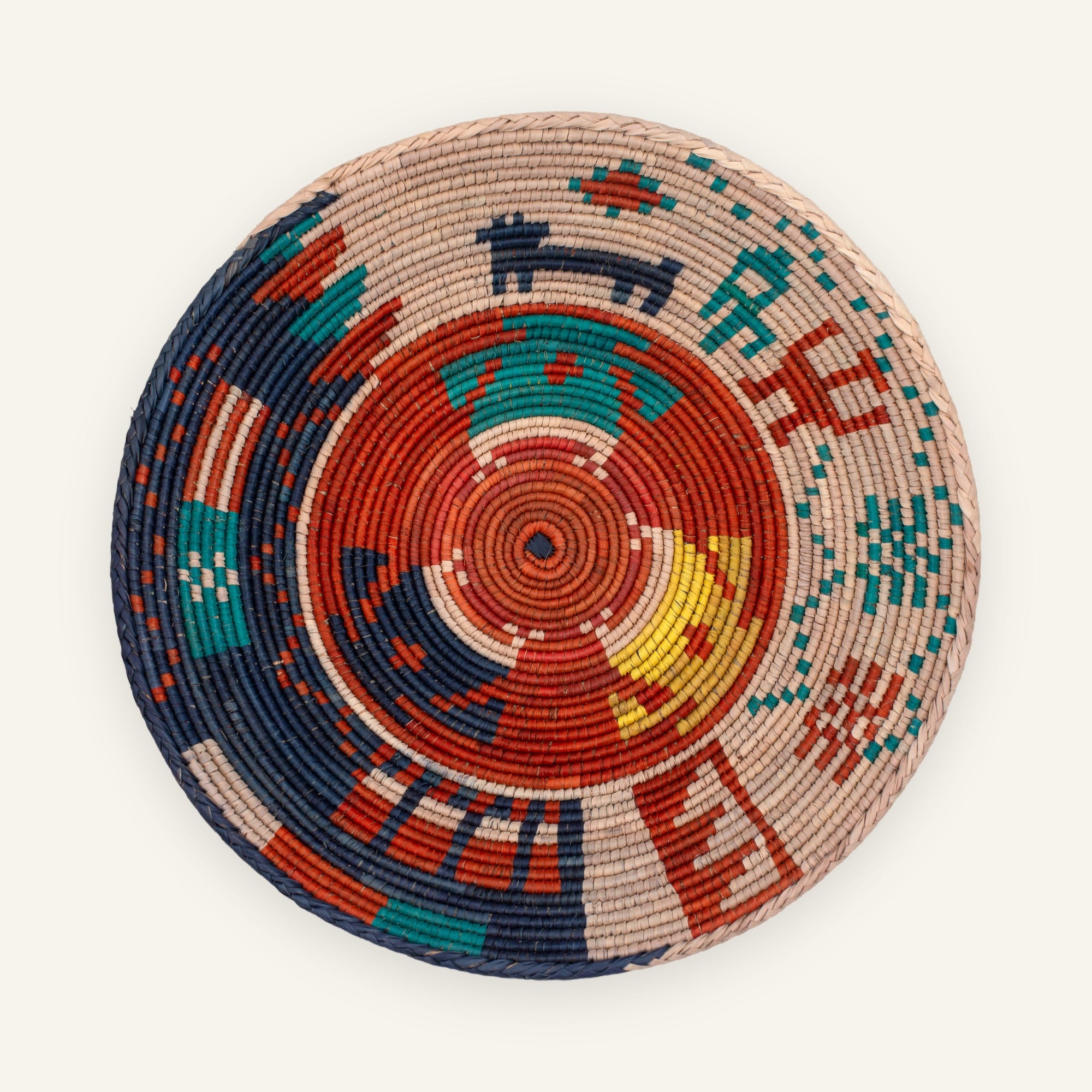 Ancient Lore Bold woven wicker wall basket with concentric geometric bands in beige, rust red, navy, teal, and yellow.