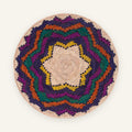 Colorblast woven wicker wall basket with a beige spiral center and geometric rings in purple, green, orange, and yellow.