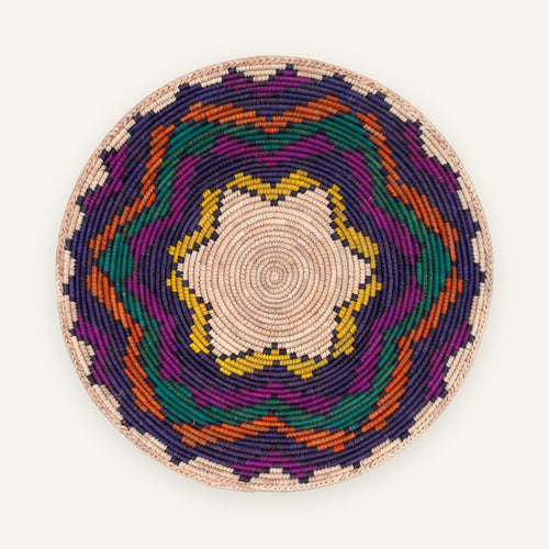 Colorblast woven wicker wall basket with a beige spiral center and geometric rings in purple, green, orange, and yellow.