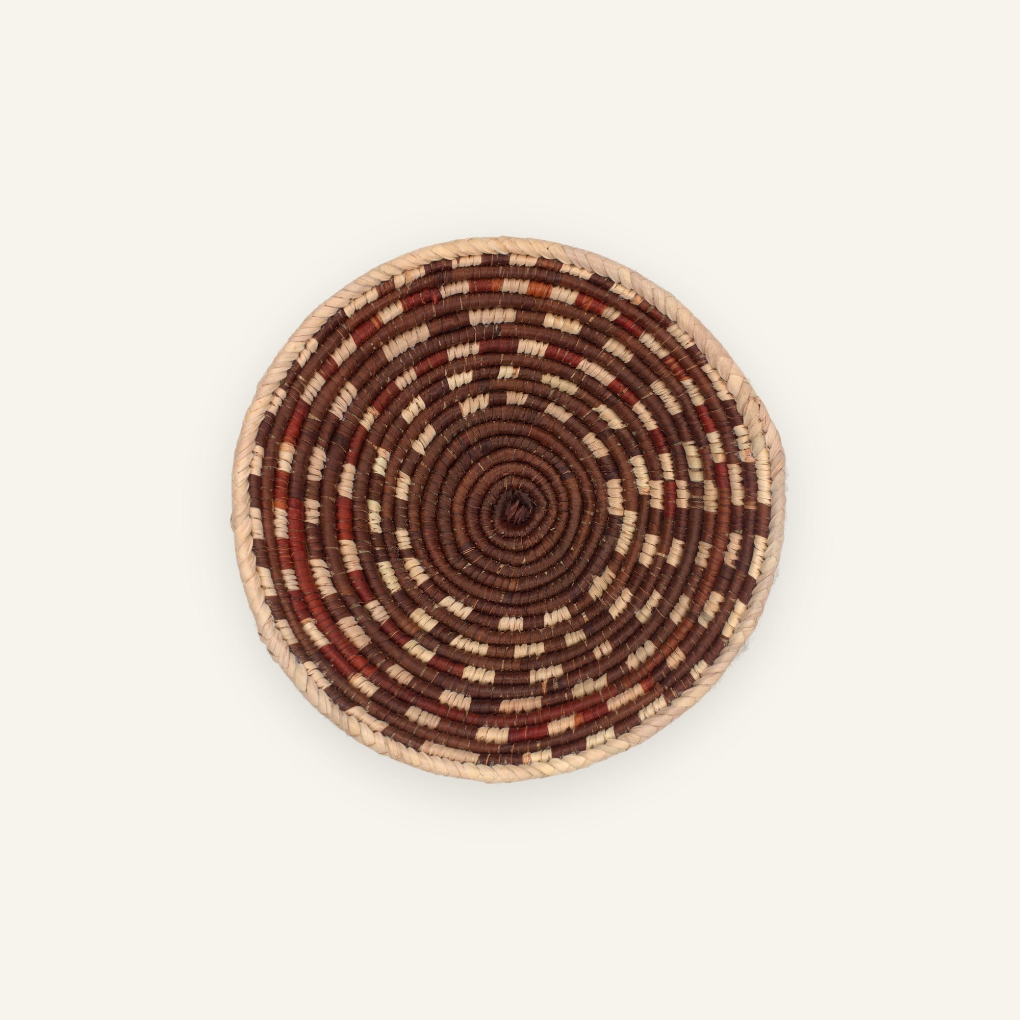 Element Dusk handmade woven wicker wall basket with concentric brown, rust red, and beige spiral bands