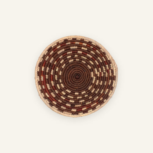 Element Dusk handmade woven wicker wall basket with concentric brown, rust red, and beige spiral bands