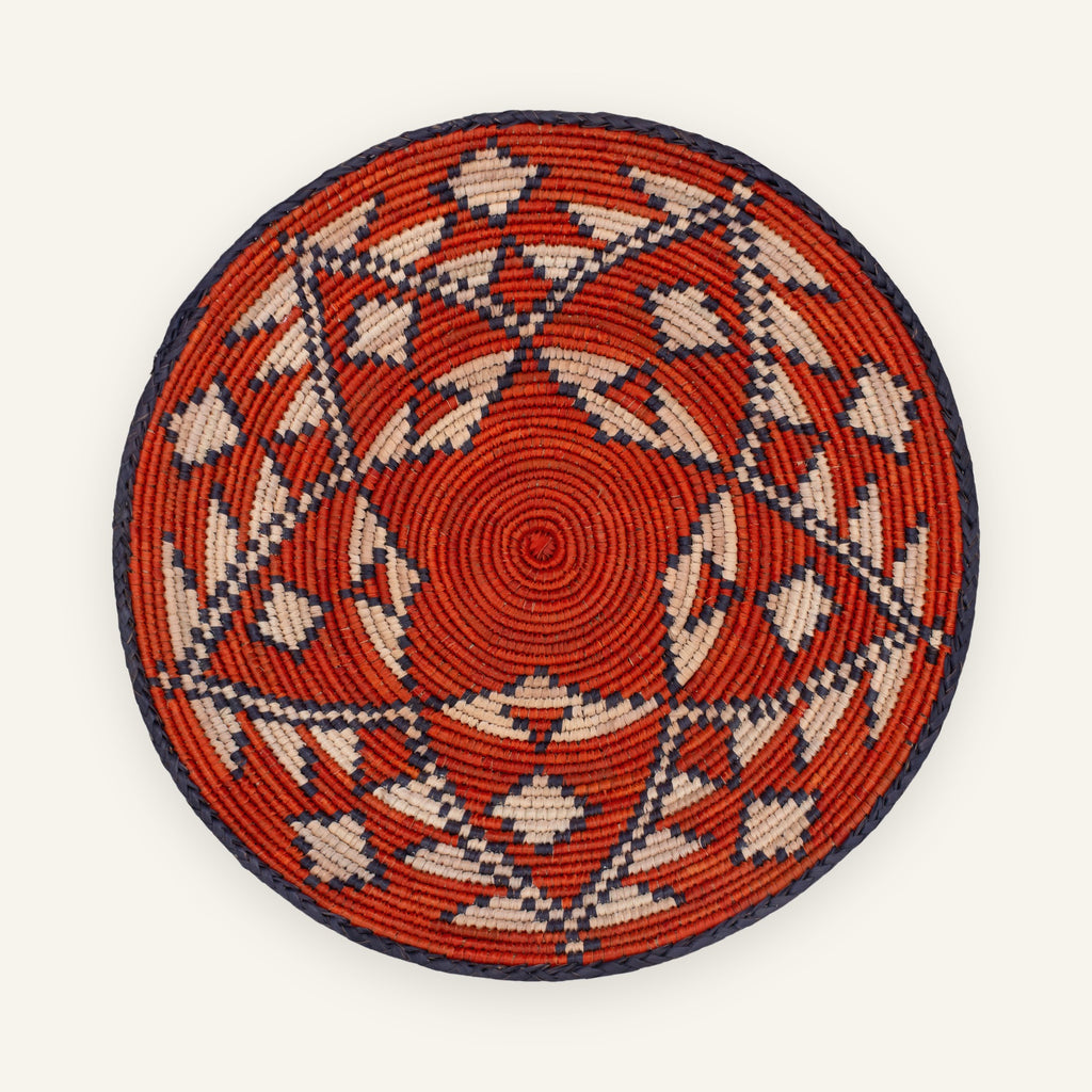 Ethnicity handmade woven wicker wall basket with red, beige, and black geometric patterns in concentric rings.