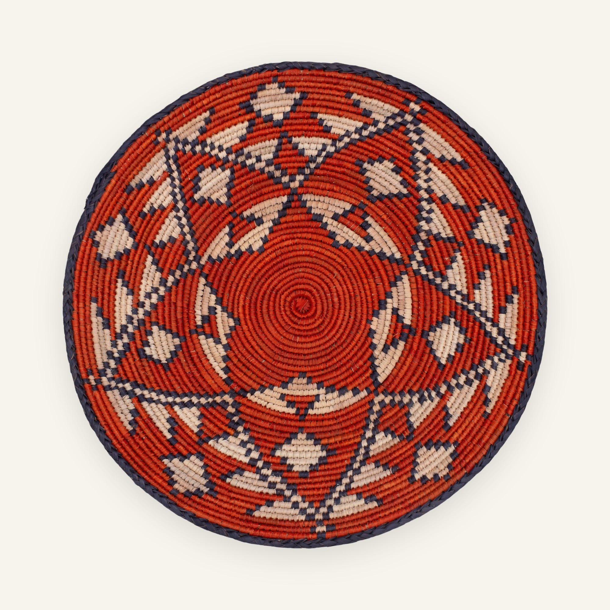 Ethnicity handmade woven wicker wall basket with red, beige, and black geometric patterns in concentric rings.