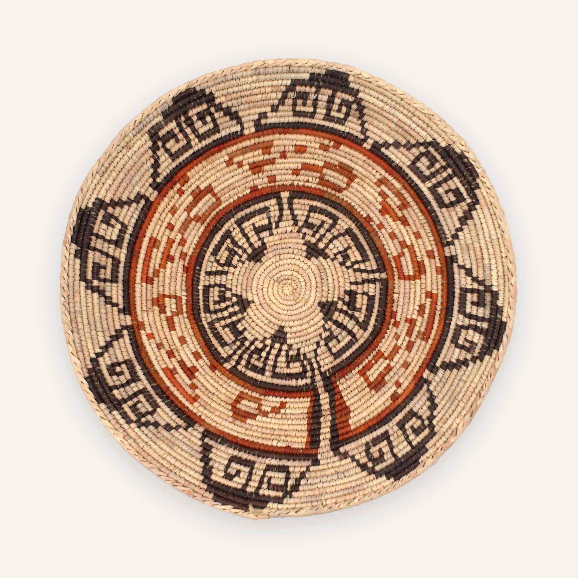 Flora woven wicker wall basket with concentric geometric bands in beige, black, and orange-brown