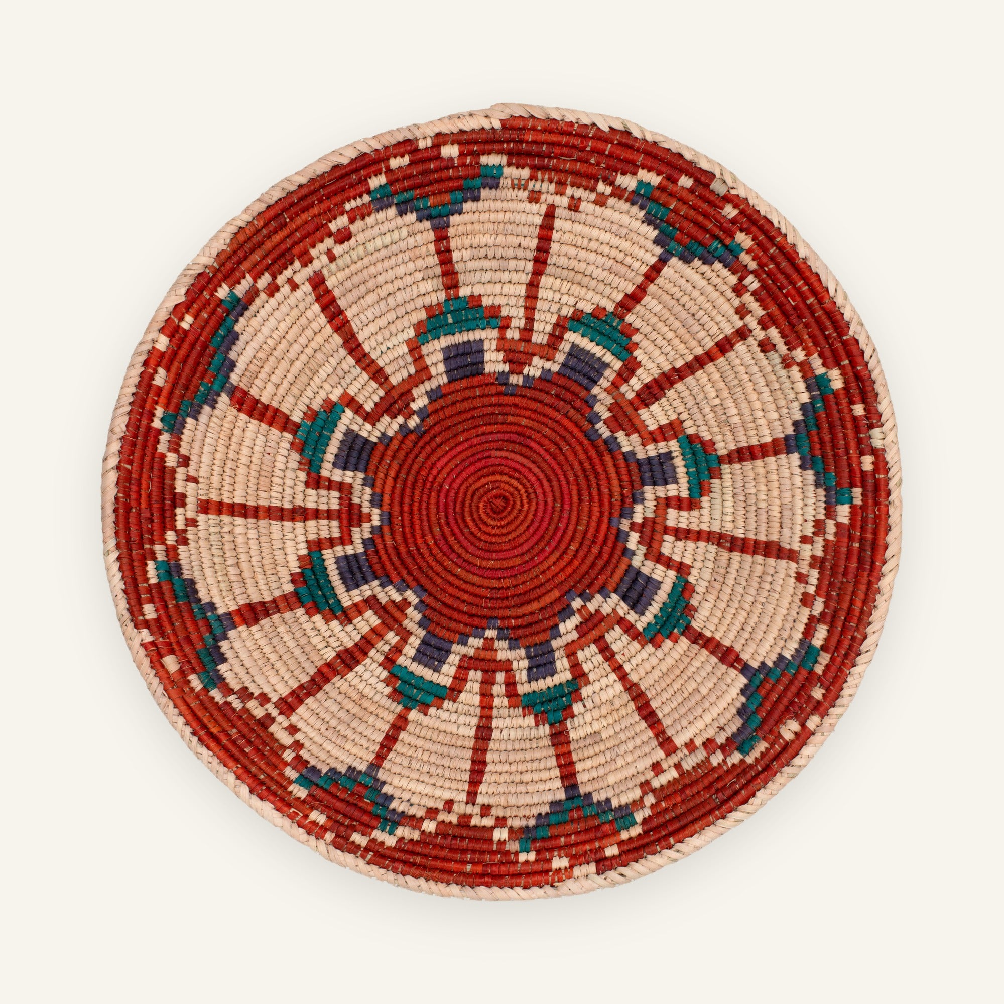 Fluorescence Ruby woven wicker wall basket with a red spiral center, beige geometric rays, teal blue and purple accents, and a red outer border.