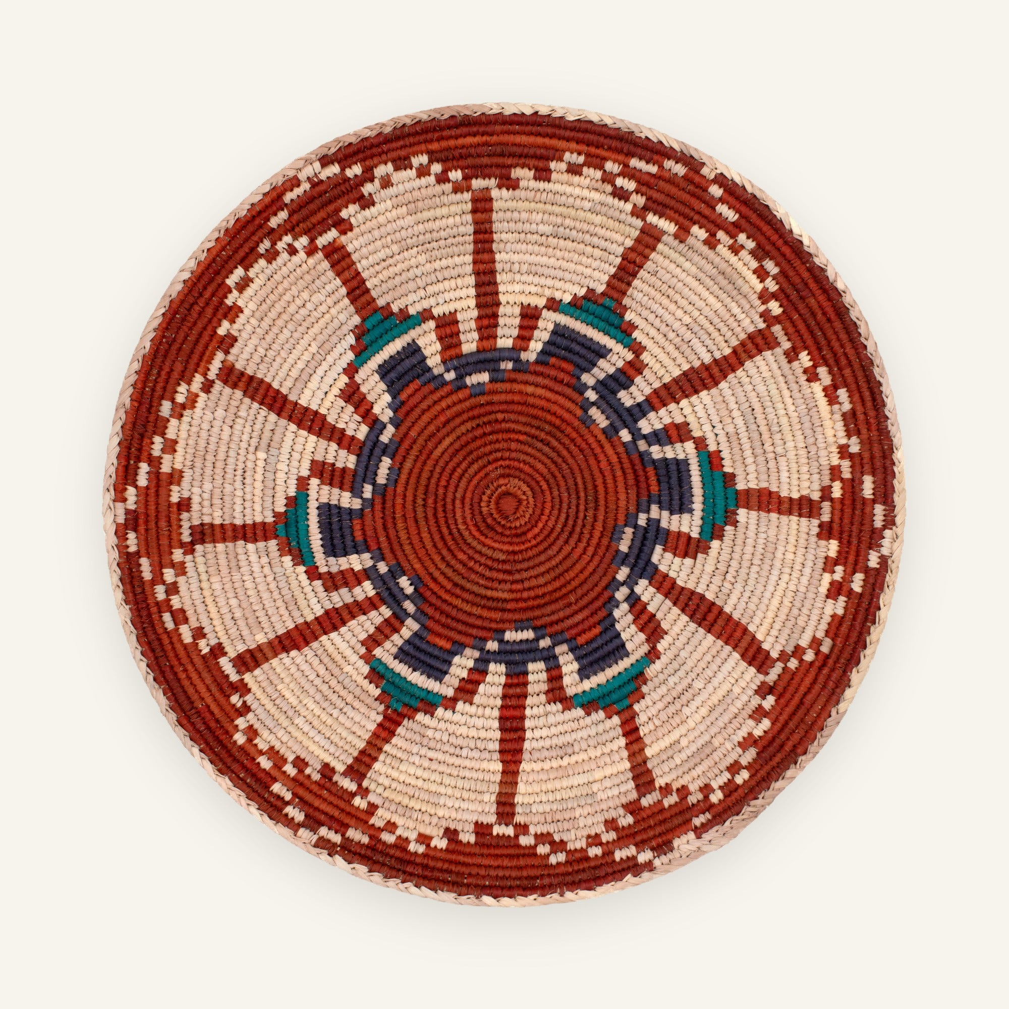 Fluorescence Subtle woven wicker wall basket with red, cream, deep blue, and teal geometric sunburst pattern