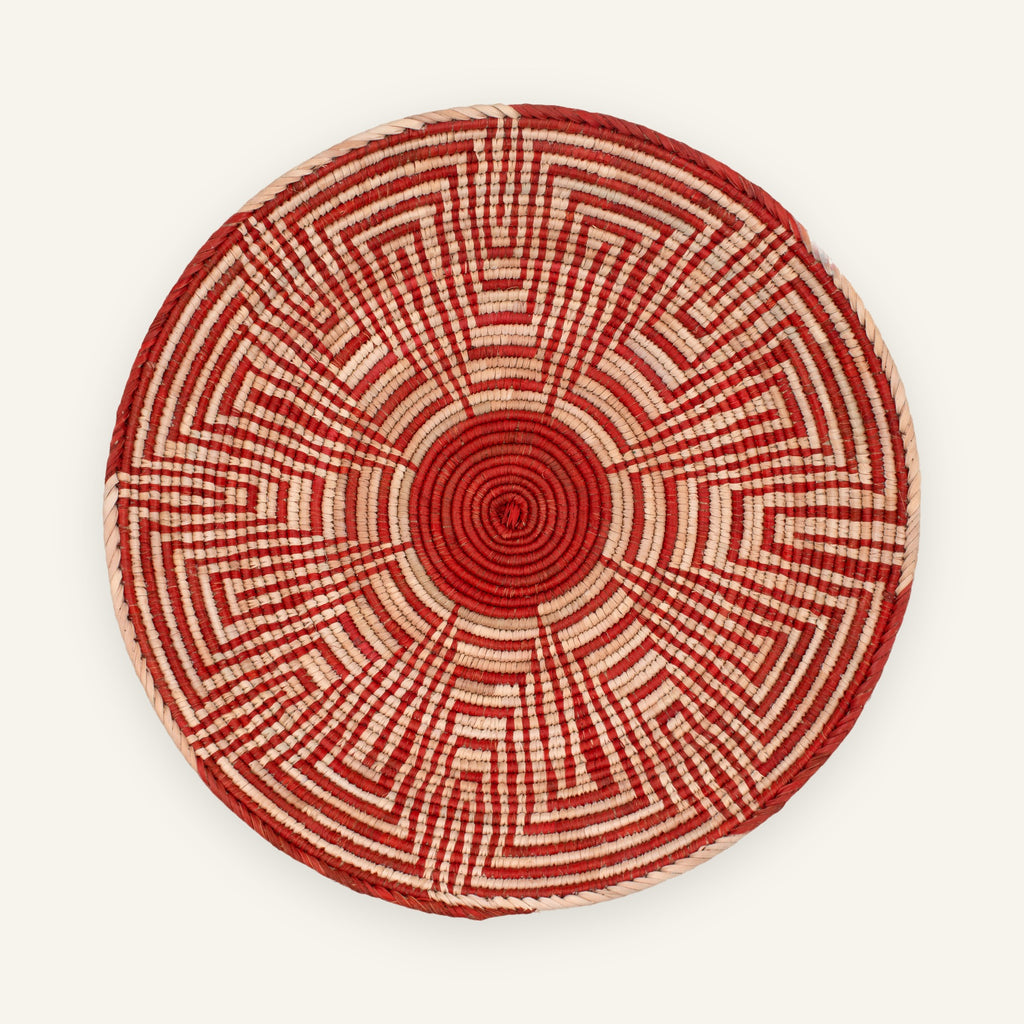 Maze Ash woven wicker wall basket with a red spiral center, beige radial geometric pattern, and rounded woven edge.