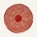 Maze Ash woven wicker wall basket with a red spiral center, beige radial geometric pattern, and rounded woven edge.