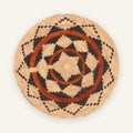 Mesa Rhythm handmade woven wicker wall basket with concentric geometric rings in beige, black, and earthy orange.