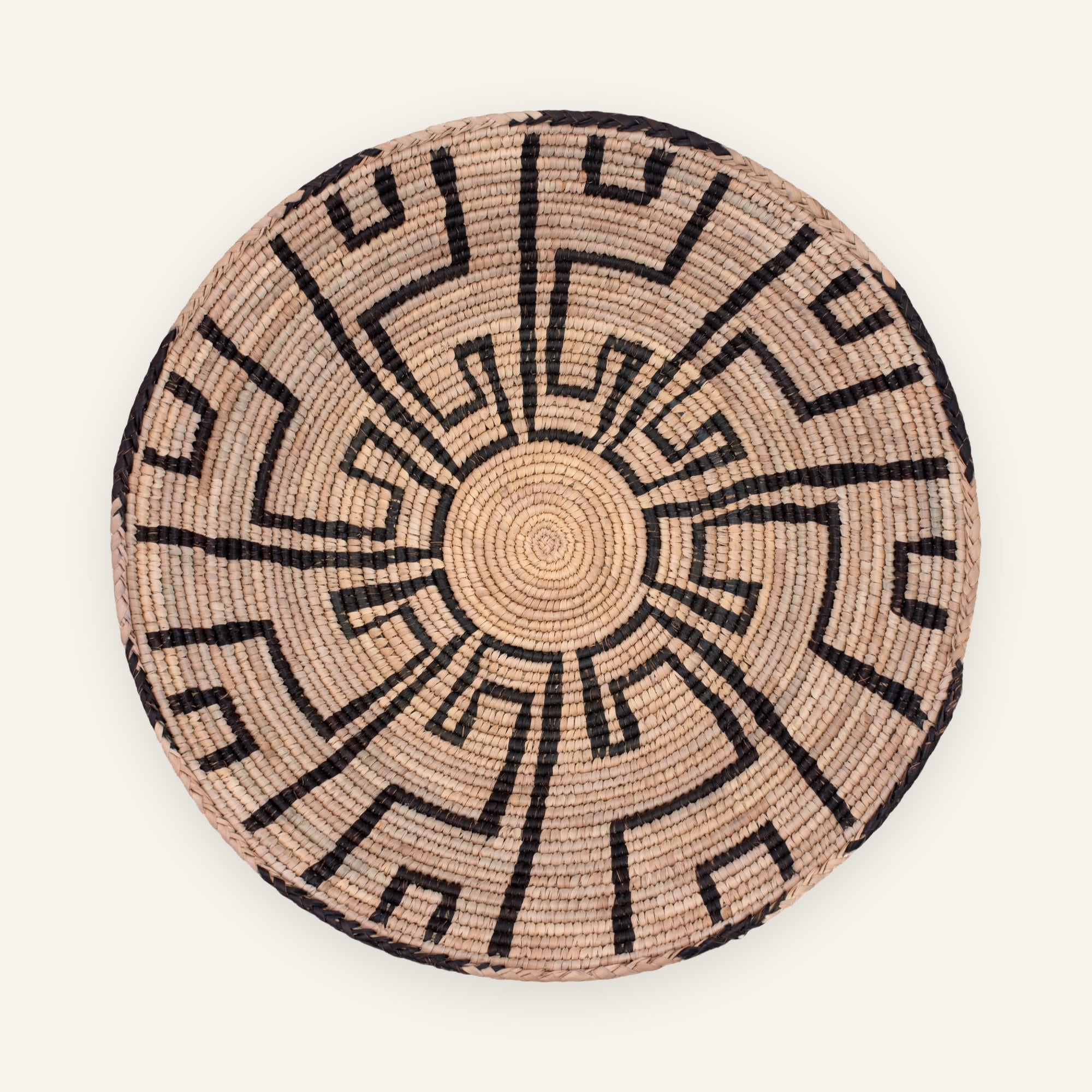 Mirage woven wicker wall basket in natural beige with a black radiating geometric pattern