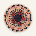 Mystery Garnet handmade woven wicker wall basket with a black center, beige ground, and red and orange geometric radial pattern.