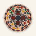 Mystery Sphene woven wicker wall basket with black, red, green, yellow, and beige geometric radial pattern
