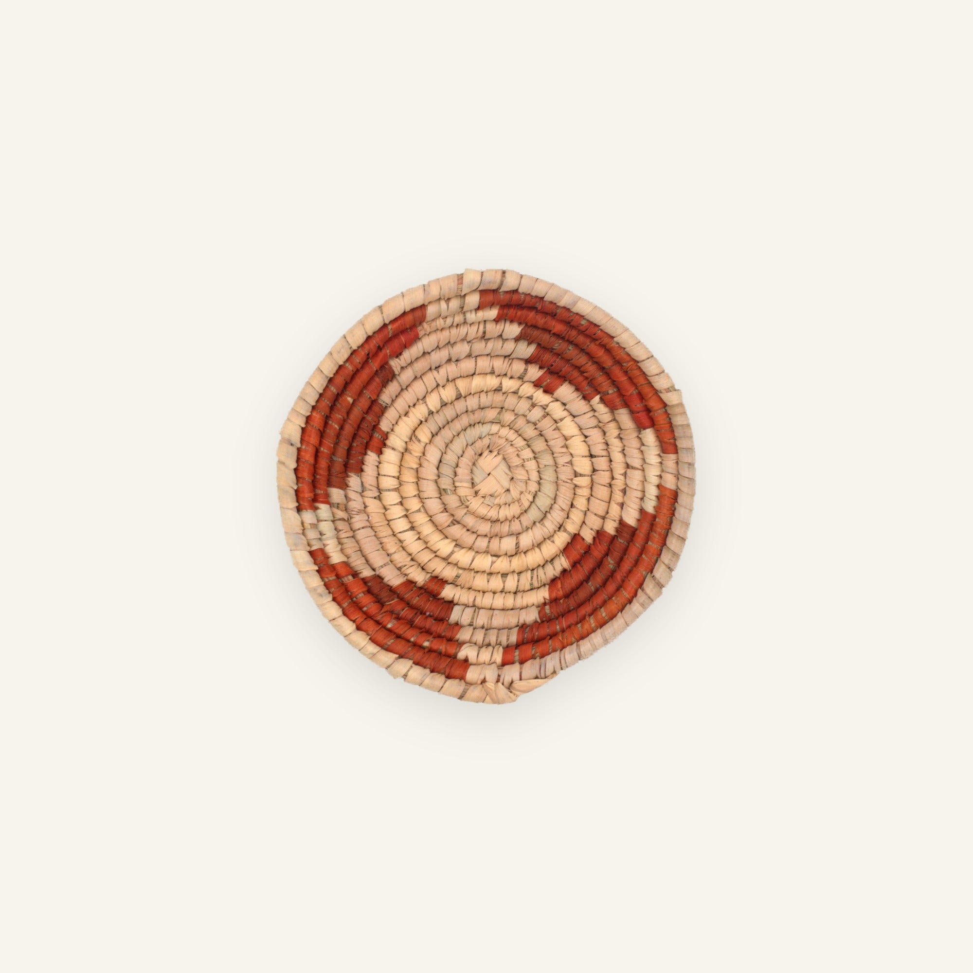 New Bud tiny woven wicker wall basket with natural beige coils and rust-toned concentric arc pattern