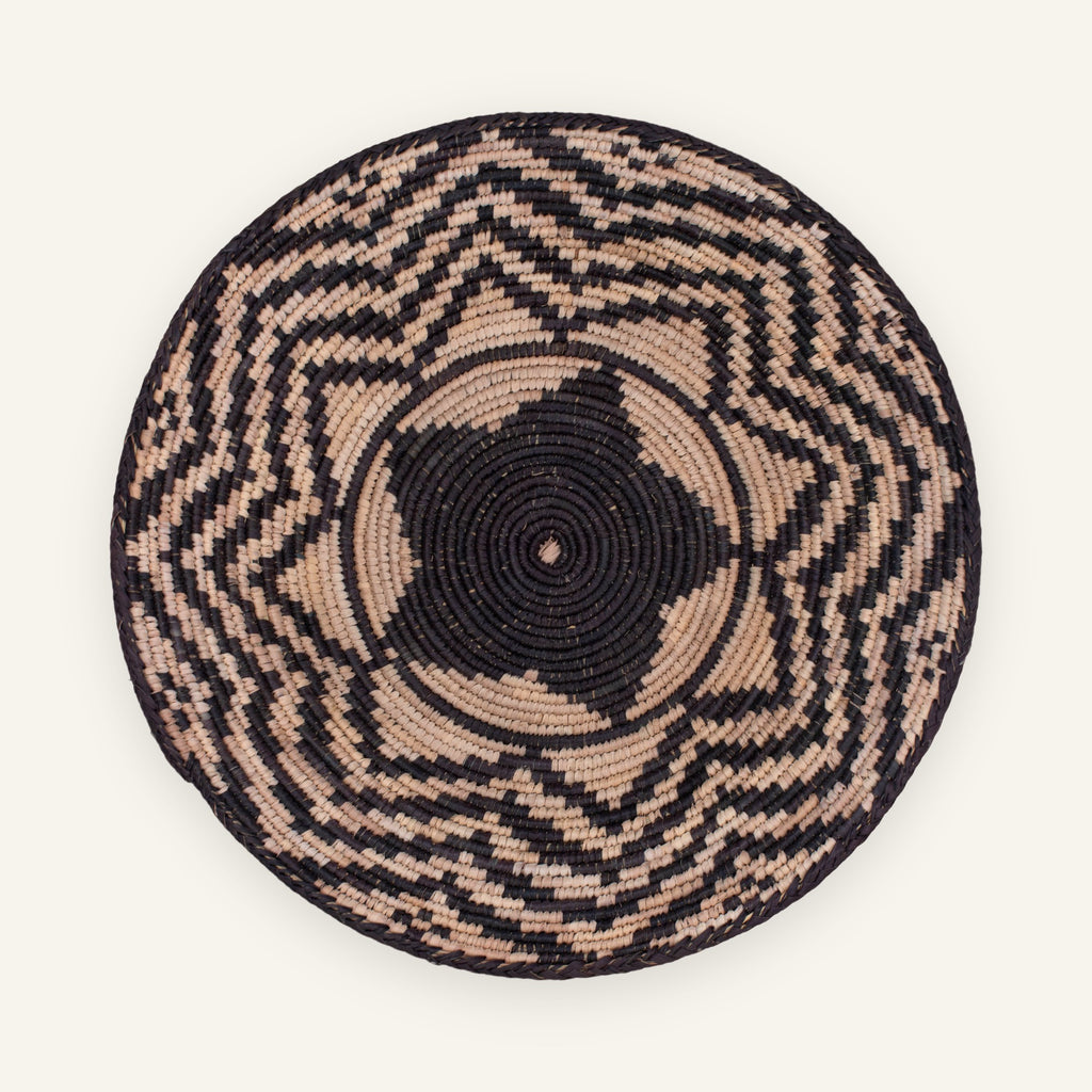 Nightfall woven wicker wall basket with a black center and irregular beige geometric bands.