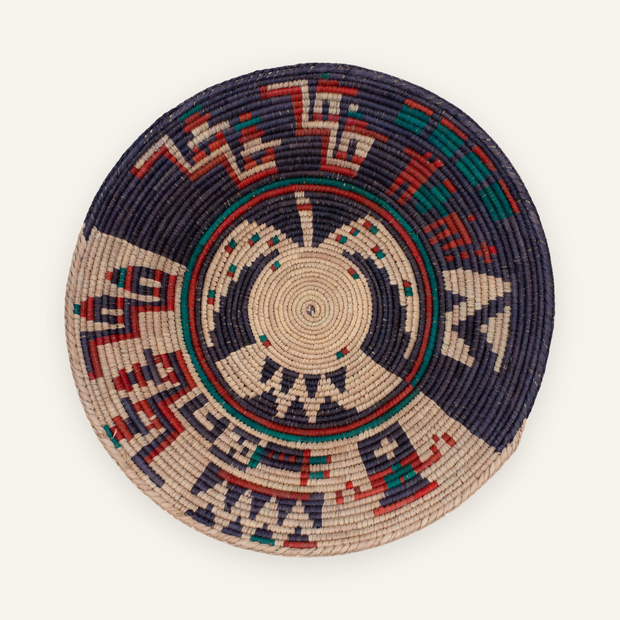 Oceanic Lore Deep woven wicker wall basket with a circular geometric pattern in deep blue, beige, red, and green