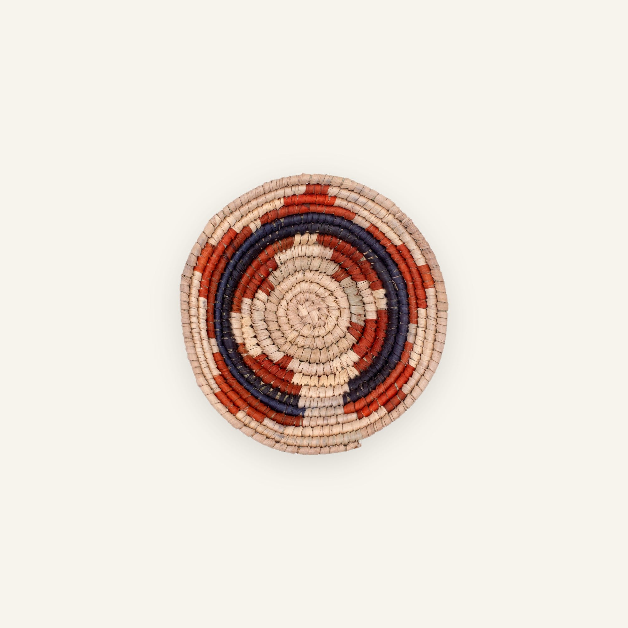 Posy mini woven wicker wall basket with concentric beige, red, and deep blue rings.