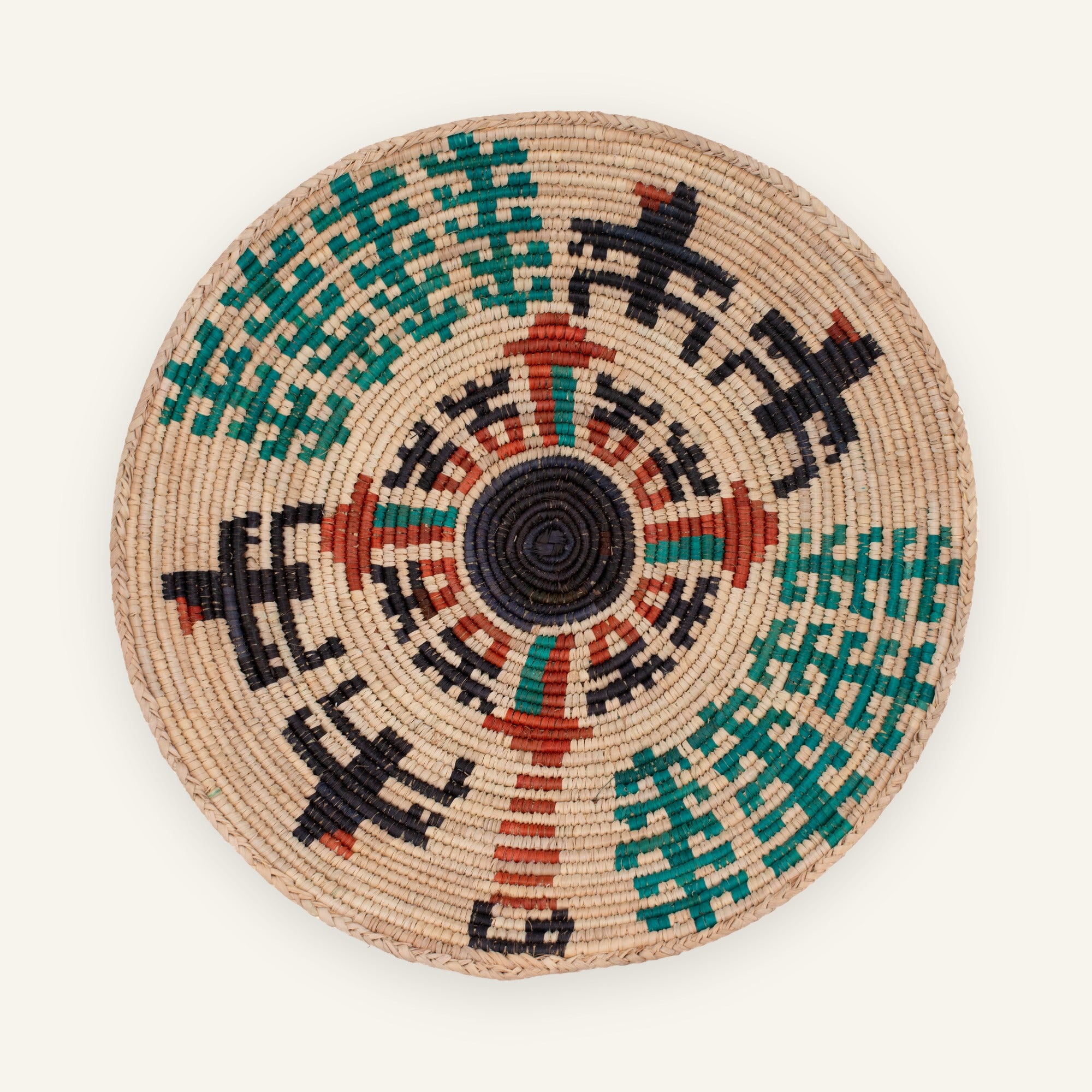 Rise woven wicker wall basket with a black circular center, green stepped bands, and red geometric accents on a natural beige ground.