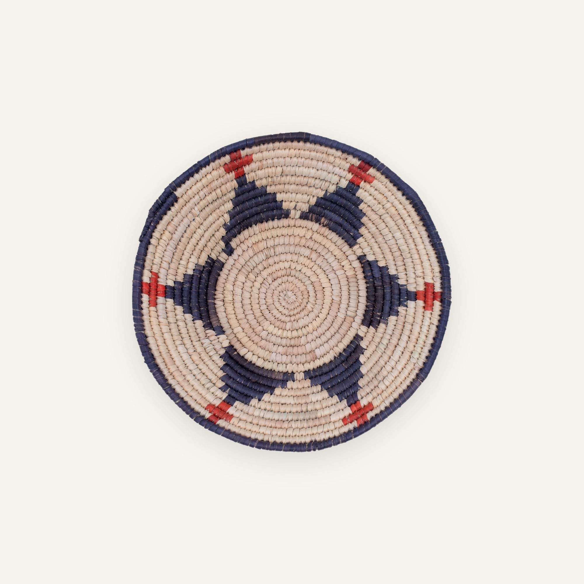 Ritual handmade woven wicker wall basket in beige with deep blue circular bands and red accent details