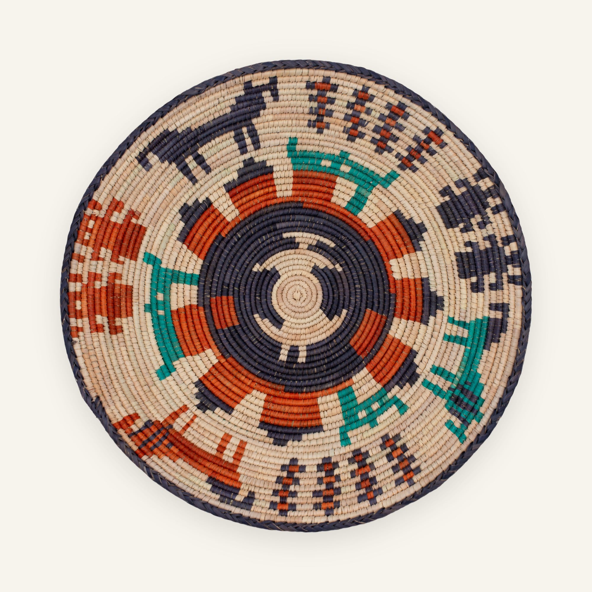 Sacrifice woven wicker wall basket with a geometric circular pattern in beige, black, orange, and green.