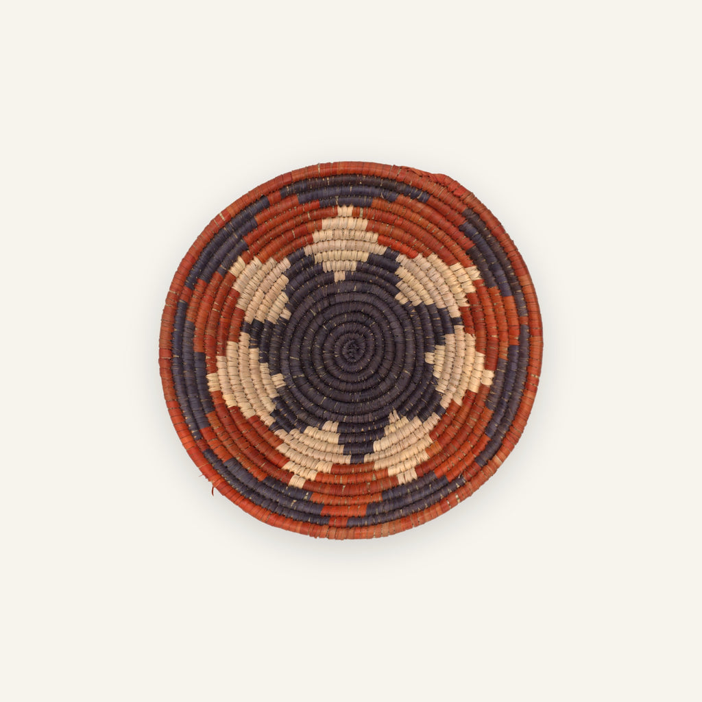 Sienna handmade woven wicker wall basket with purple, beige, and rust-orange concentric geometric rings