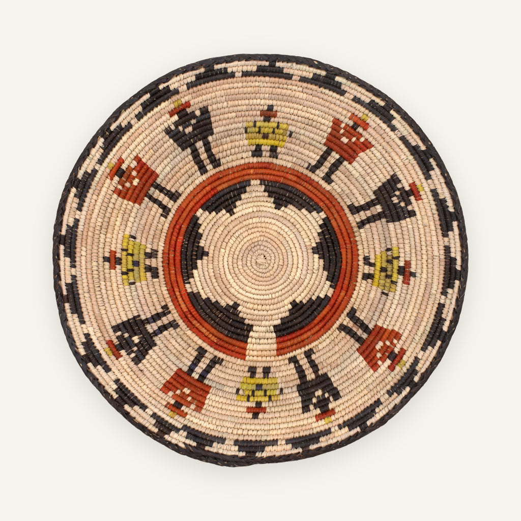 Squad woven wicker wall basket with concentric beige, black, orange, and yellow geometric patterning
