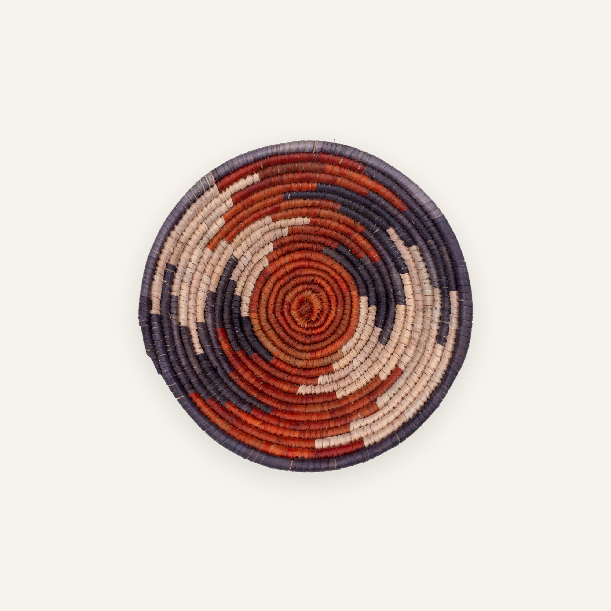 Twilight Arc handmade woven wicker wall basket with concentric rust-red, deep purple, and beige arcs