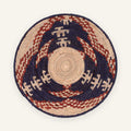 Visitors handmade woven wicker wall basket with a natural beige center, deep dark blue-black rings, and rust-red geometric arcs.