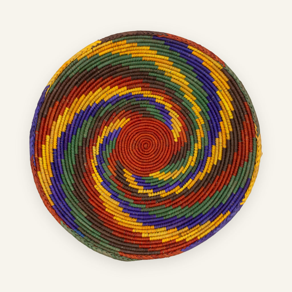 Whirlpool Origin handmade woven wicker wall basket with a red center and concentric green, purple, yellow, and brown rings